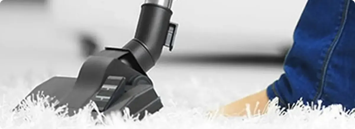 Close-up of a professional vacuuming a white carpet in Scottsdale.